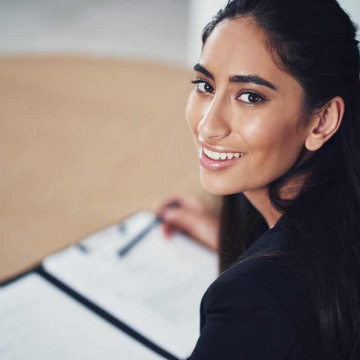 Portrait of a young businesswoman going through some paperwork in an office